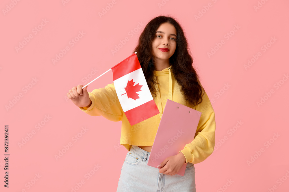 Female student with flag of Canada and clipboard on pink background Female student with flag of Canada and clipboard on pink background