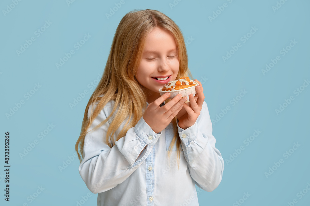 Cute little girl with tasty cinnamon bun on color background Cute little girl with tasty cinnamon bun on color background