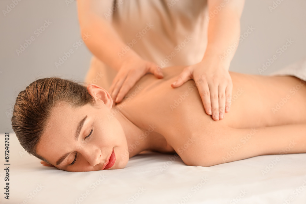 Young woman getting back massage in spa salon Young woman getting back massage in spa salon