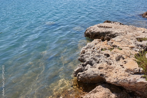 Seaside beach calm waters with rock cliff