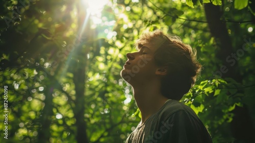 serene forest scene with young man taking a deep breath dappled sunlight filters through lush green canopy creating a peaceful atmosphere © Lucija