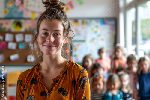 Photography of belgium school classroom scene with children in background and the teacher on front.