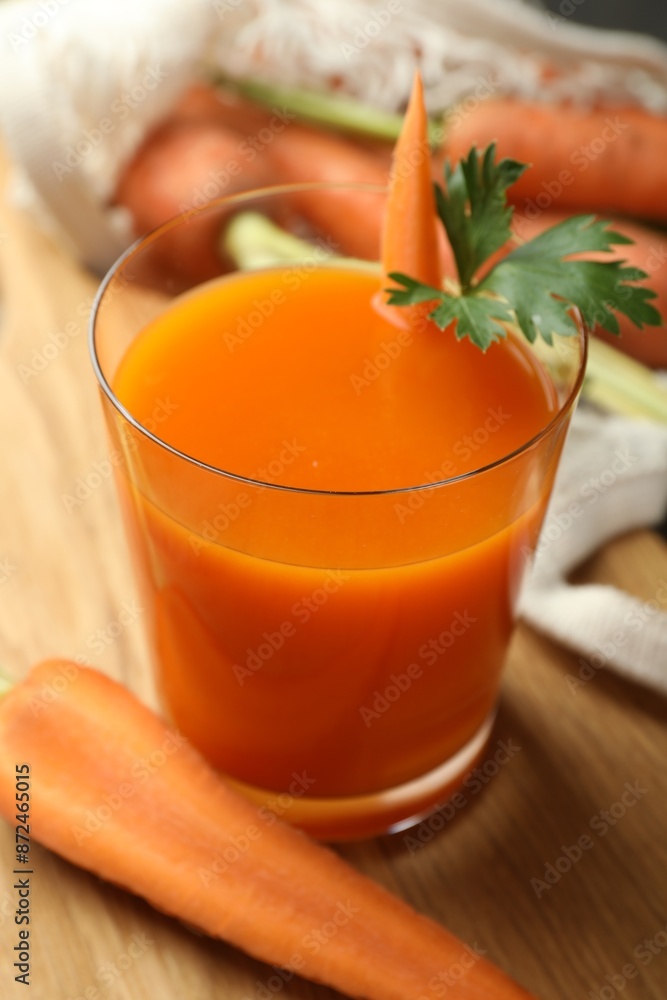 Healthy juice in glass and fresh carrot on wooden table, closeup Healthy juice in glass and fresh carrot on wooden table, closeup