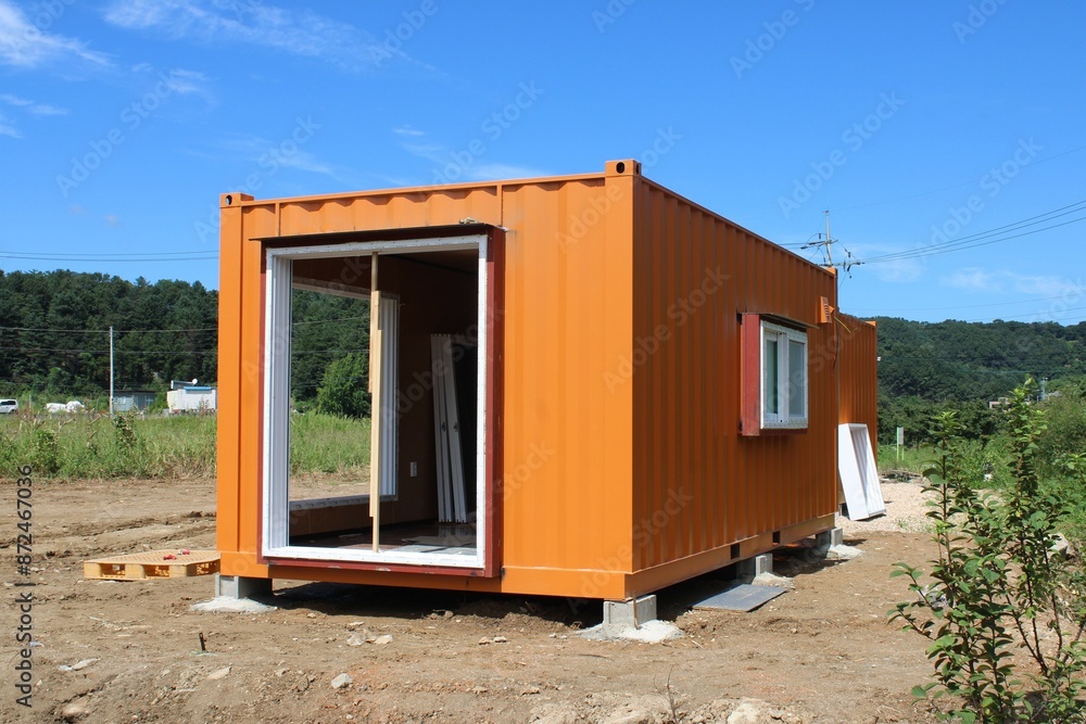 Orange shipping container hut near construction site Orange shipping container hut near construction site