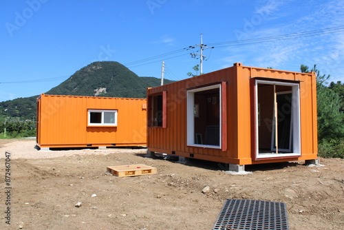 Orange shipping container huts near construction site