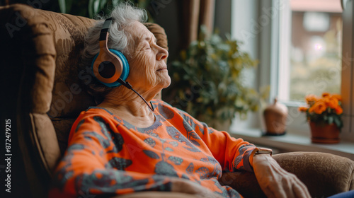 Elderly woman seated, wearing headphones