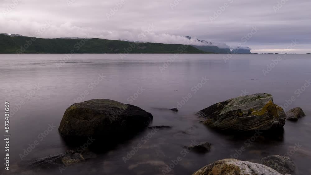 Timelapse of long exposure of a fjord and cloud formation by mountains in Senja, Northern Norway. Timelapse of long exposure of a fjord and cloud formation by mountains in Senja, Northern Norway.