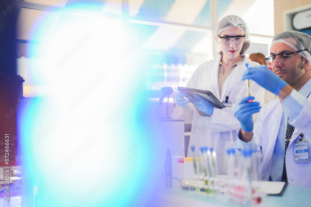 scientists perform experiments and record data. people arranges equipment with test tubes and chemicals for producing medicine and biochemistry. man hold tubes of chemical liquids and plant samples. scientists perform experiments and record data. people arranges equipment with test tubes and chemicals for producing medicine and biochemistry. man hold tubes of chemical liquids and plant samples.