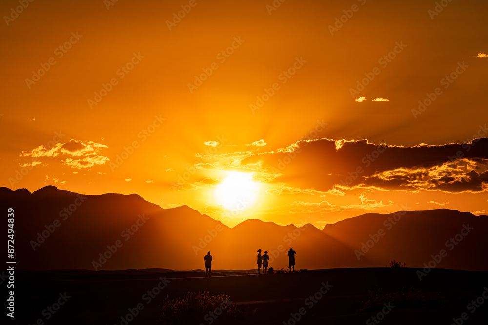 Fototapeta premium silhouette of a group of people during a sunset at white sand national park