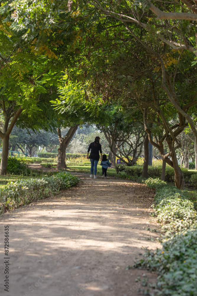 Family members holding hands while walking in a park during a sunny day in Lima Peru Family members holding hands while walking in a park during a sunny day in Lima Peru