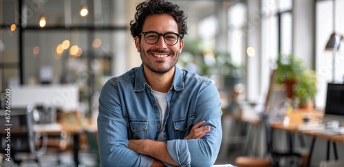 Smiling Man Wearing Glasses With Arms Crossed in Modern Office
