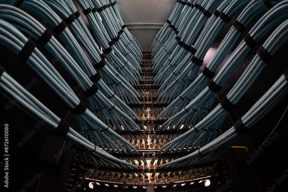 Fototapeta premium close up of network cables connected to server racks in data center room.