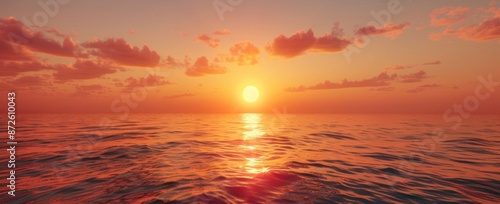 A beautiful sunset over the ocean with a large sun in the sky