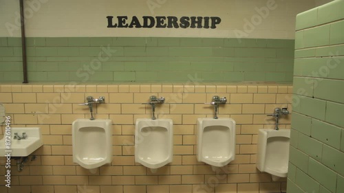 High school Male bathroom with urinals and leadership sign