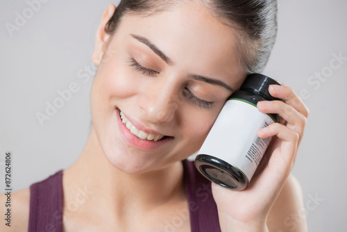 Adorable Woman Holding Medicine Bottle In Her Hands While Closing Her Eyes