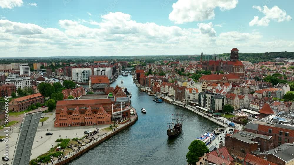 Aerial view of a vibrant waterfront area with a Ferris wheel, historic buildings in Gdańsk, and a bustling promenade along a Motława river Aerial view of a vibrant waterfront area with a Ferris wheel, historic buildings in Gdańsk, and a bustling promenade along a Motława river
