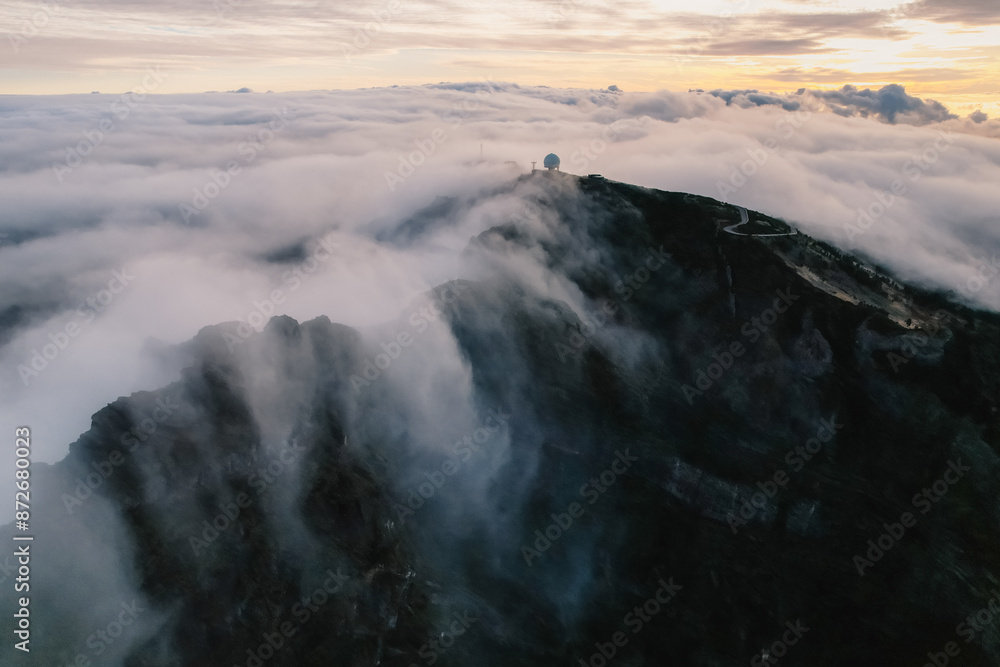 Aerial view of majestic mountain ridges at sunrise with falling fog from top of Pico do Areeiro, Madeira island, Portugal Aerial view of majestic mountain ridges at sunrise with falling fog from top of Pico do Areeiro, Madeira island, Portugal