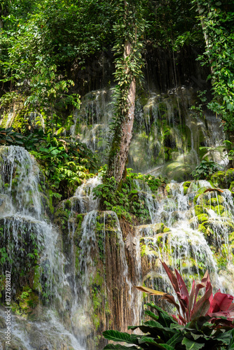 View at tropical waterfall in mountain with foliage and woods over in Luwu Timur, Indonesia. Background of fresh nature