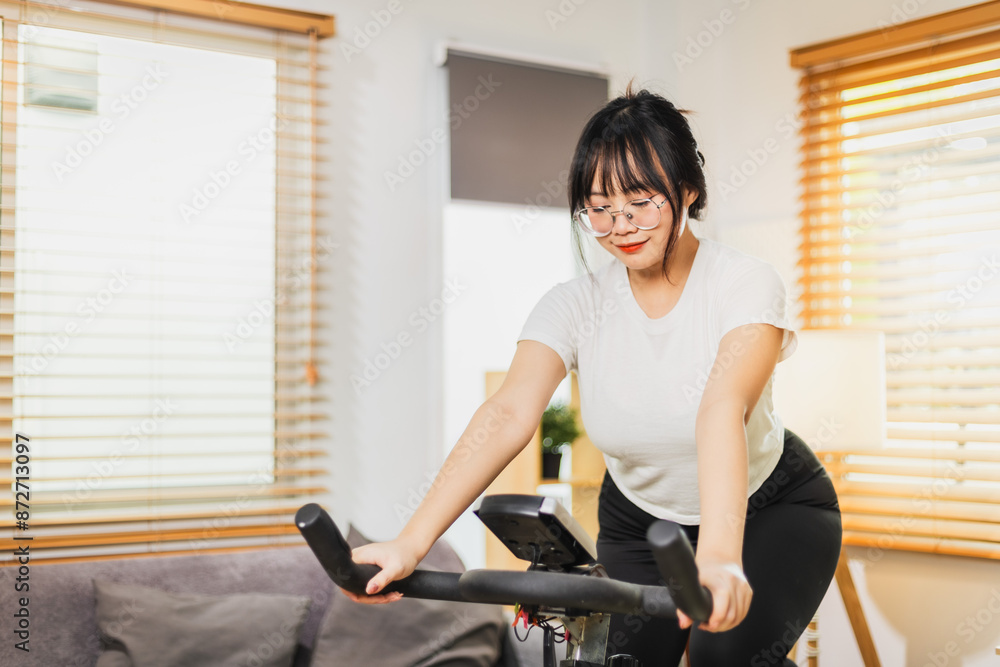 Fototapeta premium Woman using exercise equipment at home.