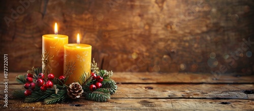 Old wooden table background with advent wreath and two burning candles provides copy space image.
