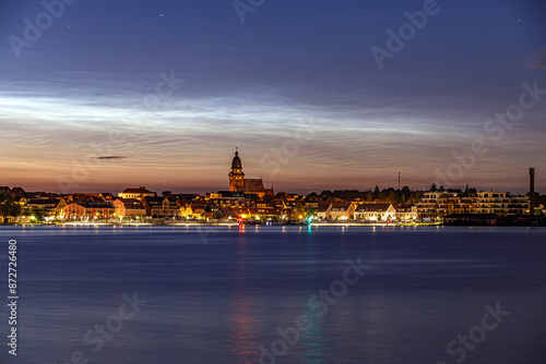 Leuchtende Nachtwolken über der Stadt Waren (Müritz) mit der Marienkirche
