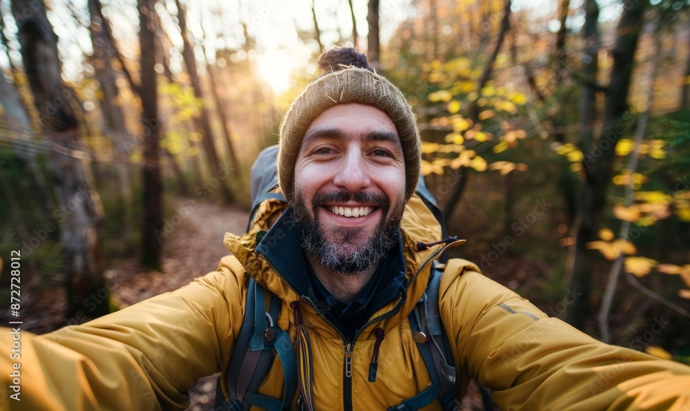 A man carrying a backpack pauses in a quiet forest to take a selfie. A man carrying a backpack pauses in a quiet forest to take a selfie.