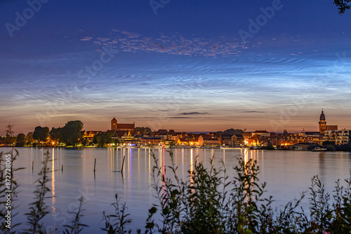 Leuchtende Nachtwolken über der Stadt Waren (Müritz) mit der Marienkirche und der Georgenkirche photo