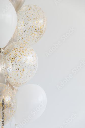 White balloons and balloons with glitter on white background on the left. Copy space.