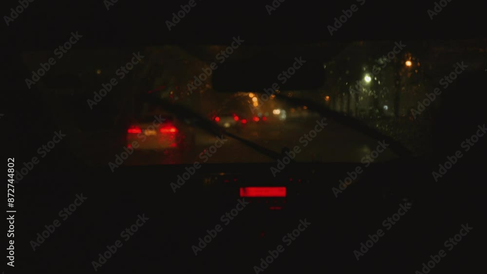 Asian Mother drives carefully in the rain because her son is sitting in the car seat. In the city where it rains heavily. Asian Mother drives carefully in the rain because her son is sitting in the car seat. In the city where it rains heavily.