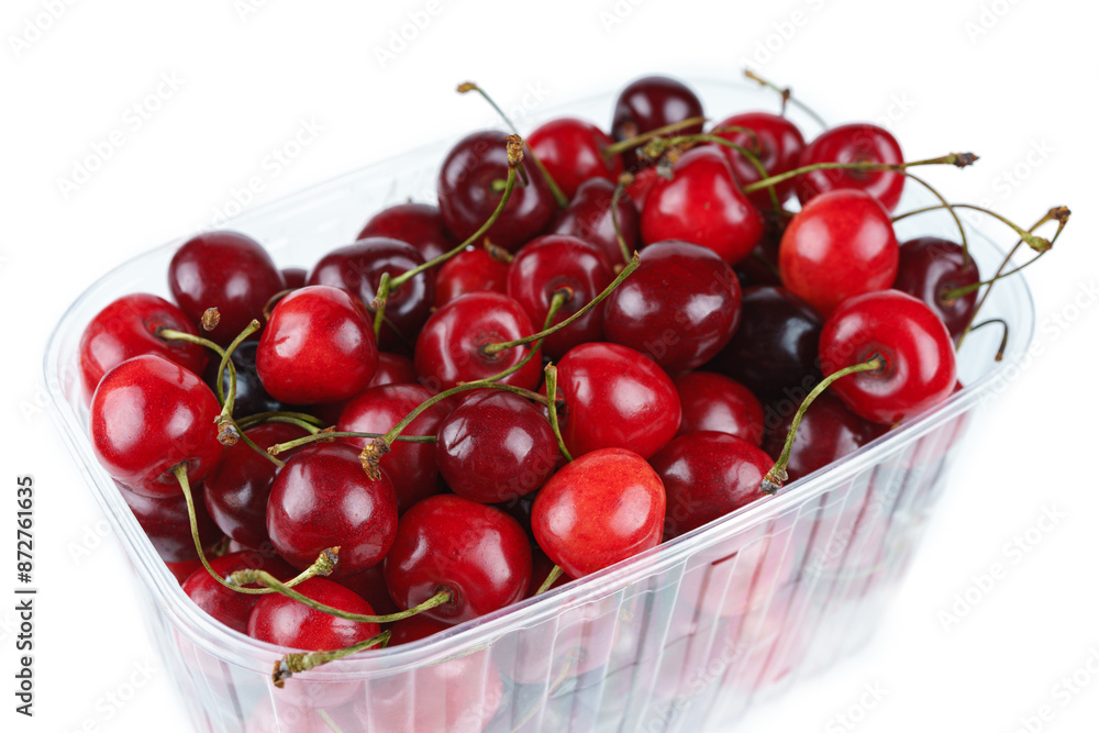 Pile of fresh ripe sweet cherry berry, fruit in transparent plastic box isolated on white background Pile of fresh ripe sweet cherry berry, fruit in transparent plastic box isolated on white background