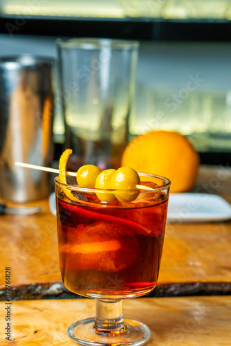 Fotografi aperitivo con bebida de vermut con aceituna y hielos muy típica de españa