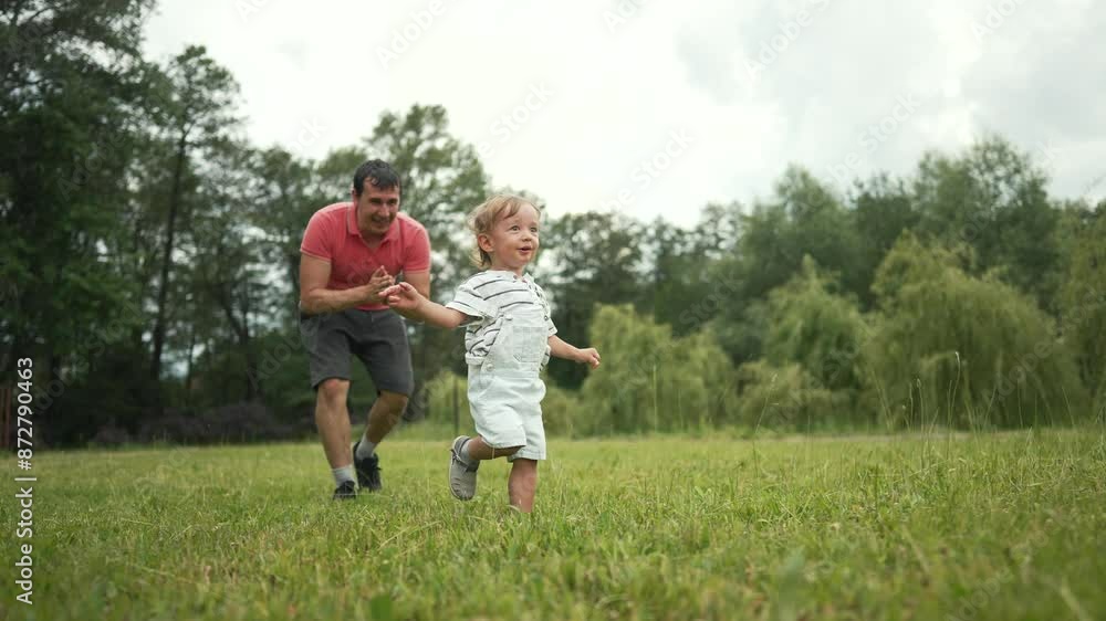 Happy family runs in park. Dad encourages toddler running on grass. Joyful moments of family run freedom in nature. Playful kid laughter fills air. Family run enjoying freedom playful fun outdoors. Happy family runs in park. Dad encourages toddler running on grass. Joyful moments of family run freedom in nature. Playful kid laughter fills air. Family run enjoying freedom playful fun outdoors.
