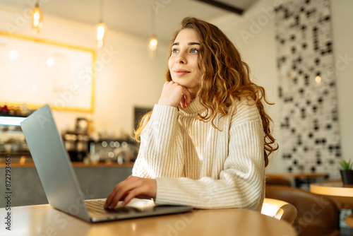 Woman freelancer using laptop while sitting in cozy cafe. Concept for education, business. Shopping online.