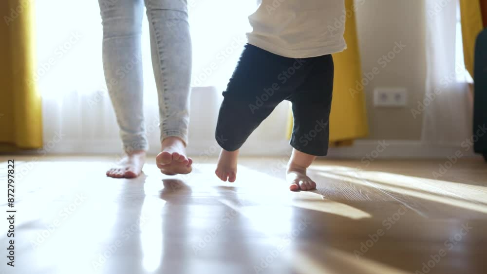 Barefoot toddler takes first step with family. Family supports toddler first step. Close up of barefoot walking. Happy family helps toddler first step. Barefoot toddler learning to walk with family. Barefoot toddler takes first step with family. Family supports toddler first step. Close up of barefoot walking. Happy family helps toddler first step. Barefoot toddler learning to walk with family.