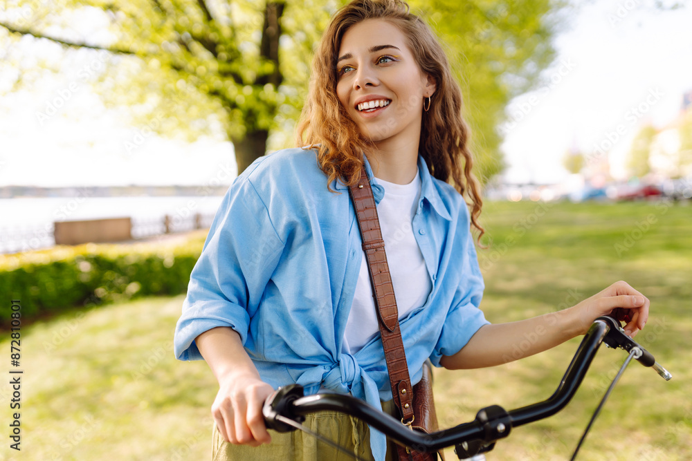 Obraz premium Happy woman riding bicycle bike in the park outdoors. Active urban healthy lifestyle concept