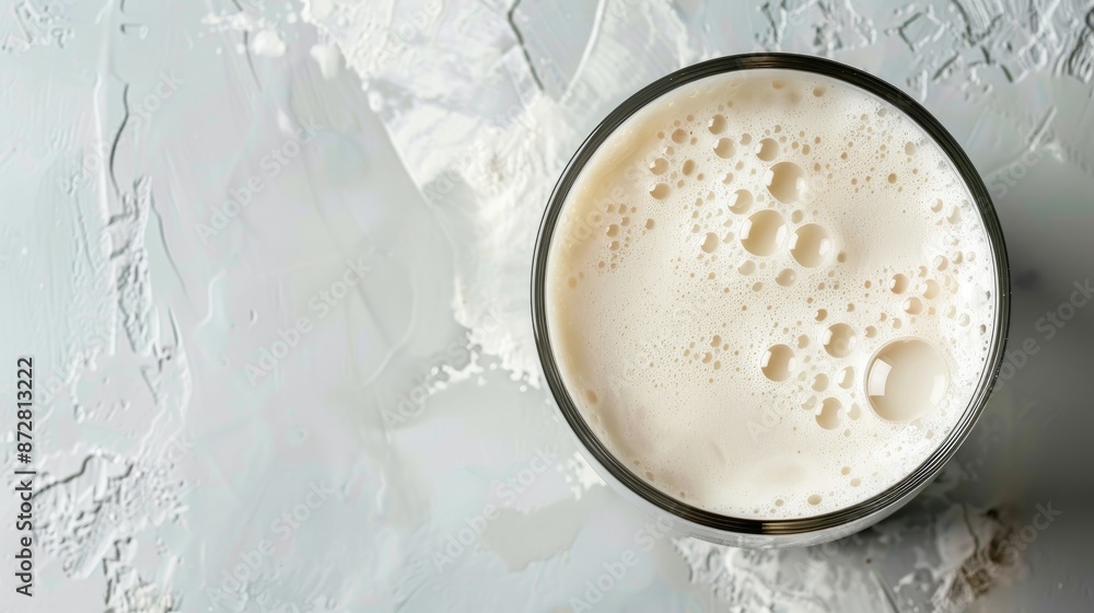 Compact frother and frothy milk in glass on neutral background with room for text Compact frother and frothy milk in glass on neutral background with room for text