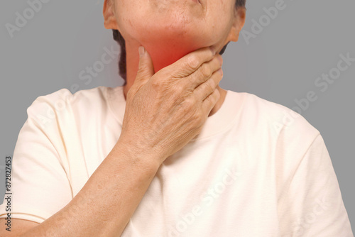 Foto Elderly woman touching her neck with sore throat