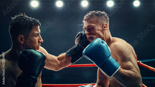 Obraz na plátně Two Male Boxers Exchange Powerful Punches in an Intense Match Under Bright Lights, Raw Strength and Fierce Competition in the Ring