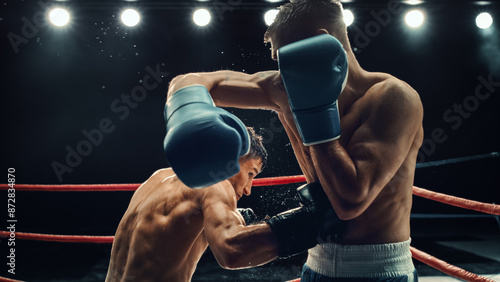 Fotografie Two Male Boxers in High-stakes Match, Exchanging Powerful Blows Under Intense Lighting