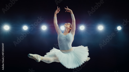 Obraz na płótnie Skilled Ballet Dancing Ballerina in White Tutu Performs High Grand Jeté Under Bright Stage Lights, Her Elegance, Strength, and Artistry in Captivating Ballet Performance
