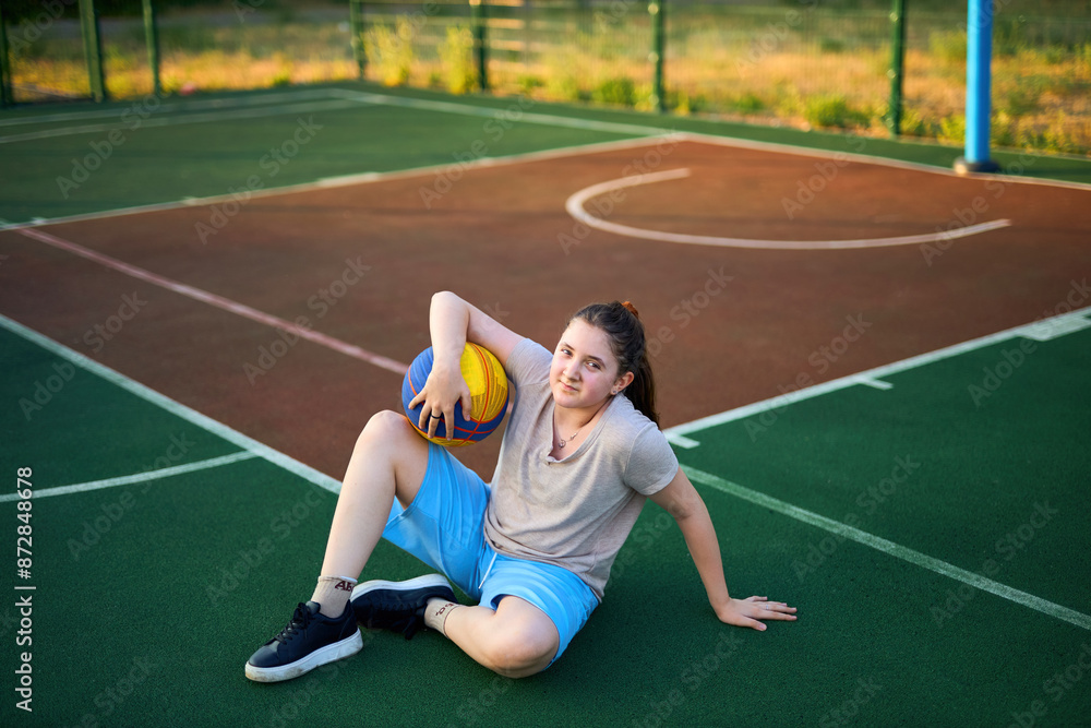 Obraz premium Lifestyle portrait of Cheerful caucasian little girl ten years old holding game ball