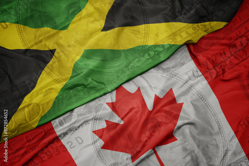 waving colorful flag of jamaica and national flag of canada on the dollar money background. finance concept. photo