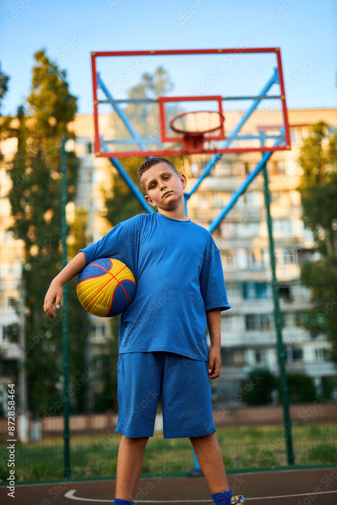 Portrait of a boy with a basketball on a basketball court. Portrait of a boy with a basketball on a basketball court.