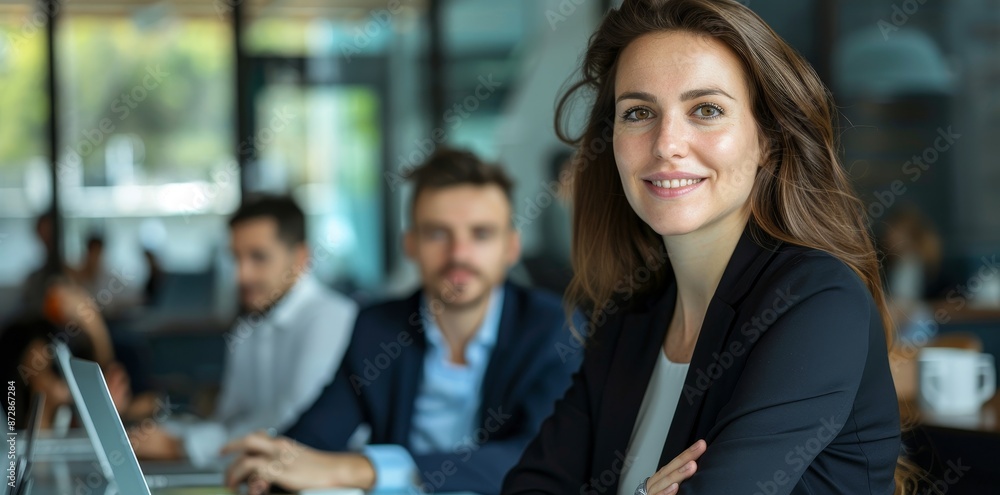 An enthusiastic young woman works at a computer in a bright, modern workplace. An enthusiastic young woman works at a computer in a bright, modern workplace.