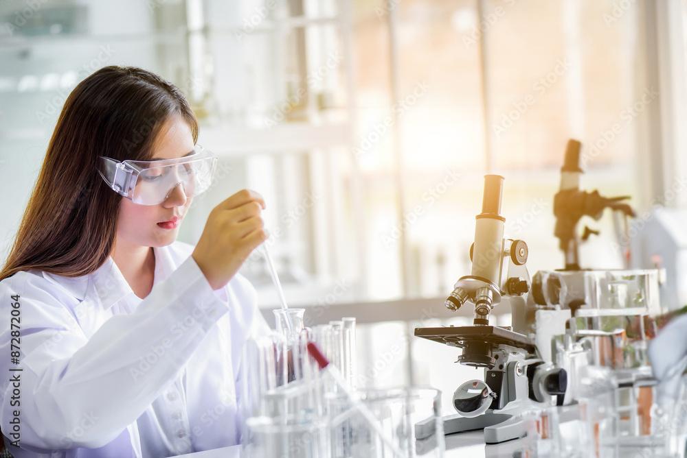 Attractive young Asian scientist woman lab technician assistant analyzing sample in test tube at laboratory. Medical, pharmaceutical and scientific research and development concept Attractive young Asian scientist woman lab technician assistant analyzing sample in test tube at laboratory. Medical, pharmaceutical and scientific research and development concept
