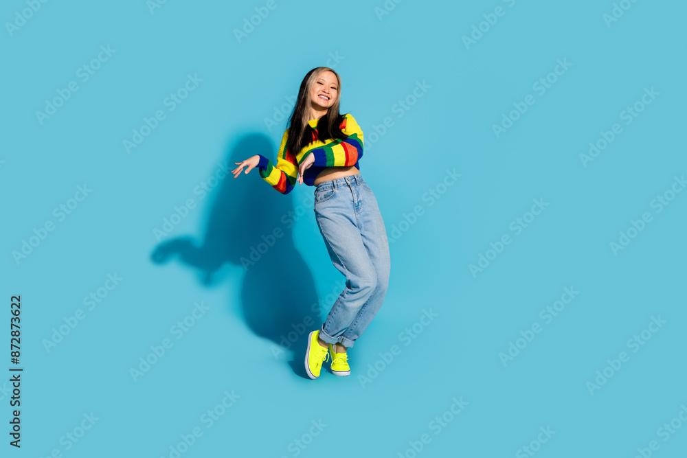 Obraz premium Full length photo of lovely young lady enjoy disco dancing tiptoes dressed stylish striped garment isolated on blue color background