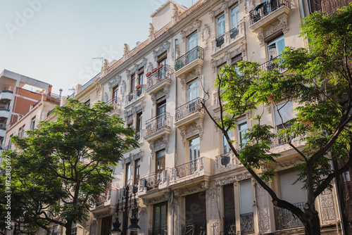 Wallpaper Mural Facade of a historic building with intricate designs, framed by lush green trees. The combination of classic architecture and natural elements enhances the urban aesthetic. Torontodigital.ca