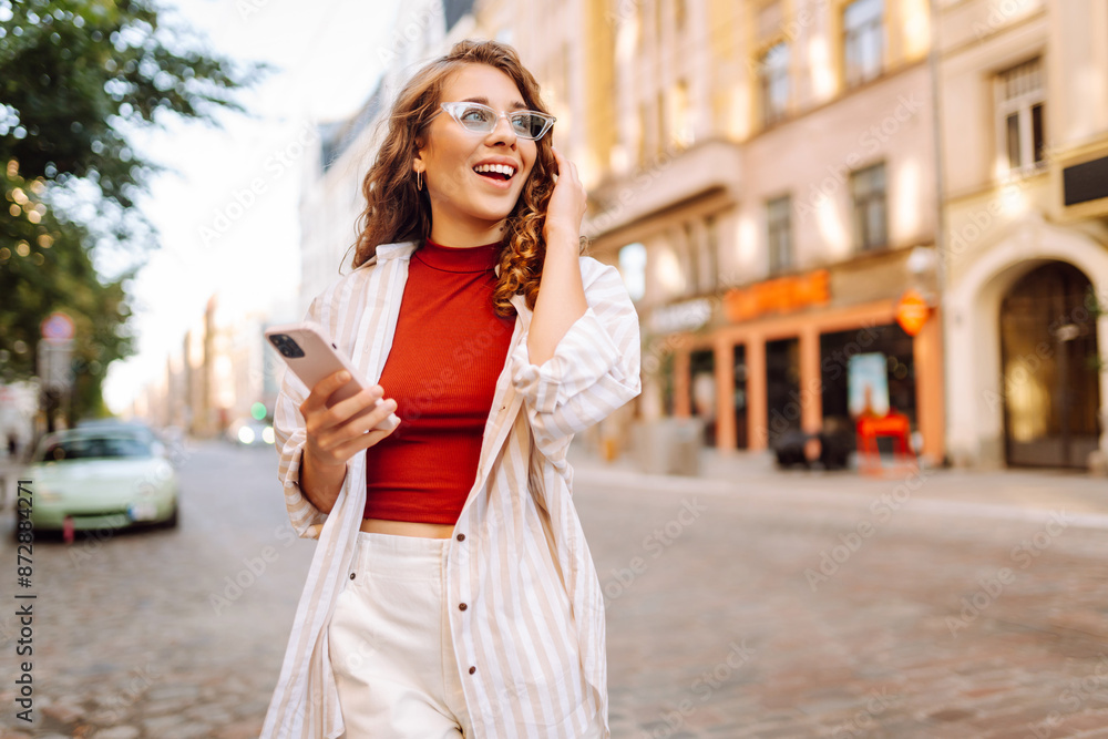 Fototapeta premium Young woman tourist walking around the street, making selfie, communication with friends. Networks, blogging, online shopping concept.