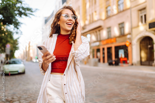 Young woman tourist walking around the street, making selfie, communication with friends. Networks, blogging, online shopping concept.