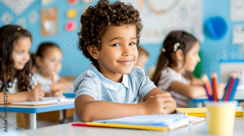 Elementary school children in their desks in a diverse and multicultural classroom setting.
